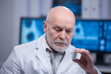 Elderly professor is doing a science experiment in a modern laboratory. Genetic engineers...