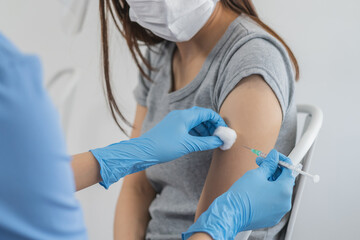Covid-19, coronavirus hand of young woman doctor or nurse  giving syringe vaccine, inject shot to arm patient. Vaccination, immunization or disease prevention against flu or virus pandemic concept.