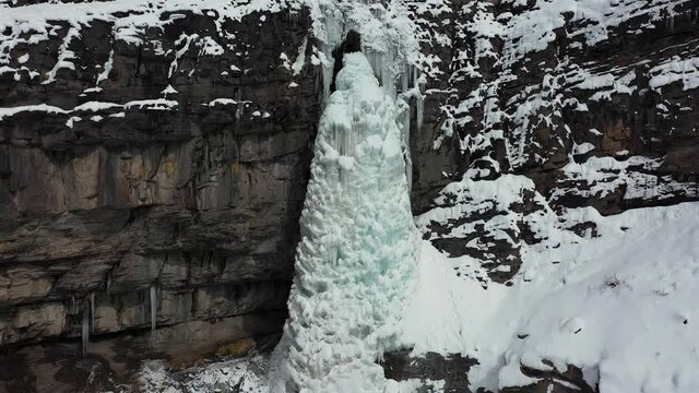 Aerial view of ice mass tower from frozen waterfall in Ouray Ice Park, Colorado USA, drone shot