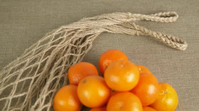 Reusable sack with oranges. Eco-friendly string bag with tangerines. Zero waste.