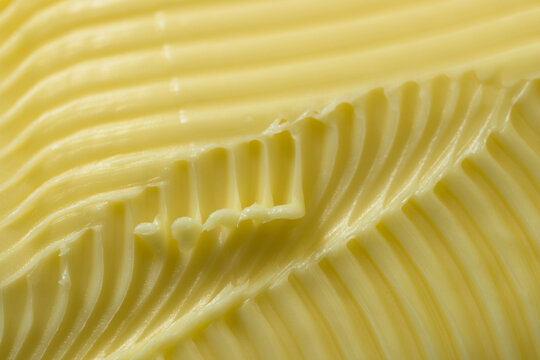 Butter close up with grooves and flicks creates textured background.