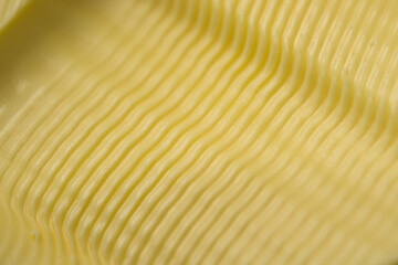 Tiny wavy ripples in yellow butter, super macro close up of a texture