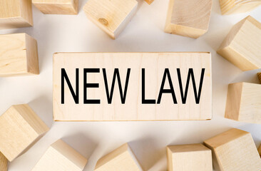NEW LAW. text on a piece of wood. on a white background