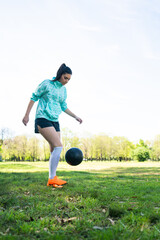 Young woman practicing soccer skills with ball.