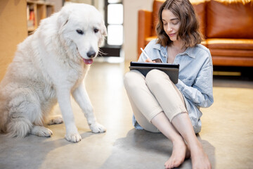 Woman with a dog and digital tablet at home