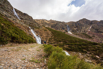 Fototapeta na wymiar Estany de la Gola. On an early spring day. In the midst of the melting snow of winter, forming waterfalls on the tops of the mountains that end at the bottom of the valley.