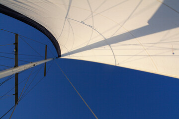 Concept of freedom. Beautiful white sail with blue clean sky on background