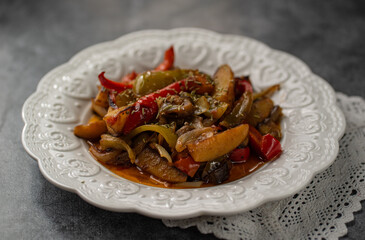 vegetable stew - ciambotta in a ceramic white plate on the background