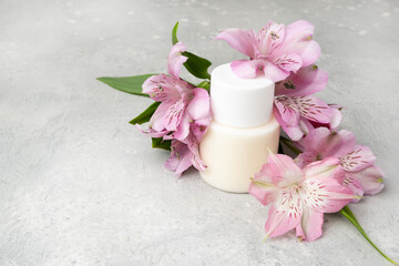 Obraz na płótnie Canvas Cosmetics SPA branding mock-up. White cosmetic bottle containers with with pink exotic flowers on gray background. Natural organic beauty product concept, Minimalism style