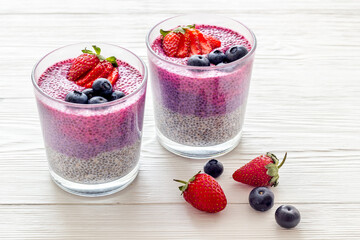 Chia pudding smoothie dessert wirh strawberries in glass jars. Vegan healthy breakfast.