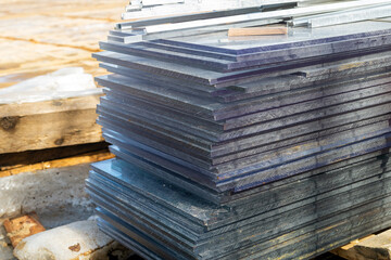 A stack of thick glass for building in the mud.