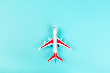 Airplane model, airliner with red wings, on a blue background. travel and transport concept