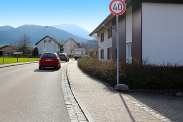 Cars behind a lorry on road through a village (Münstertal, Baden, Germany)