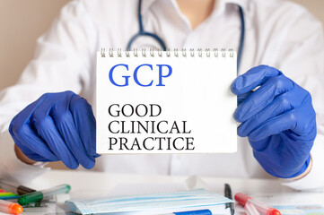 Doctor holding a tablet with text: gcp. gcp - good clinical practice, medical concept.
