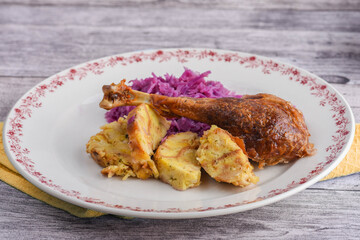 Roasted goose leg in sauce with red cabbage and potato dumplings