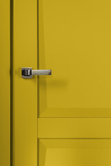 Stainless stylish door knob on yellow wooden door
