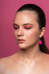 Fototapeta premium Lovely woman, round pink earrings and beautiful professional makeup
