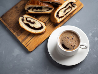 homemade pastries a poppy seed bun, a cup of coffee on the table