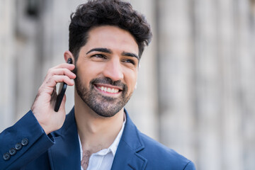 Businessman talking on phone outdoors.