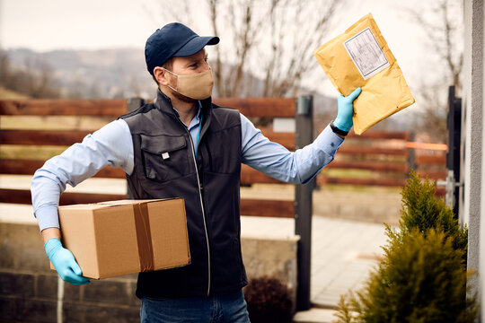 Postal Worker Wearing Face Mask While Delivering Mail And Package To Customer's Home Address.