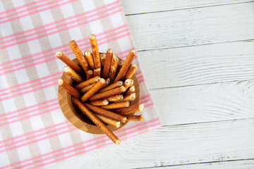 salted straw biscuits in a wooden bowl on wooden background flat lay