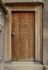 An intricately carved wood door leads into the 9th-century church of Surp Poghos-Petros (St. Paul and St. Peter) at Tatev Monastery, Armenia.