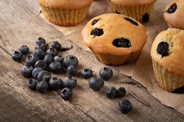 muffin with blueberries on a wooden table. fresh berries and sweet pastries on the board.