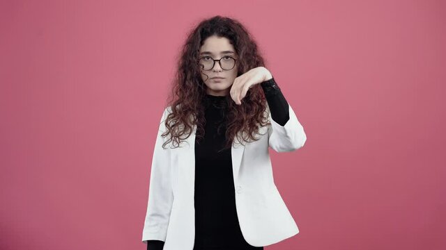 Serious young woman with curly hair, looks like a basket with thousands in her mouth that she will keep the message a secret, promises silence.