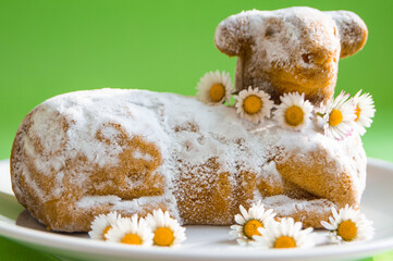 Traditional Easter lamb cake with powdered sugar is decorated with delicate spring daisies.