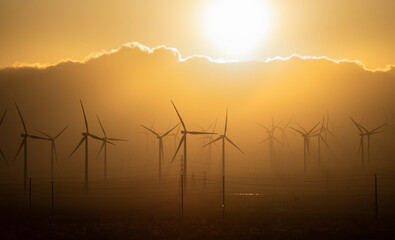 wind energy turbine with windmills and  Orange sky sunset