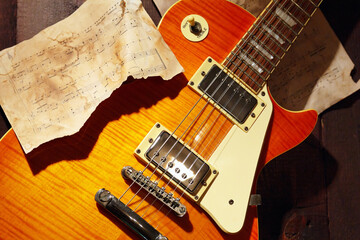 Still life with a jazz vintage electric guitar and rare music notes closeup.