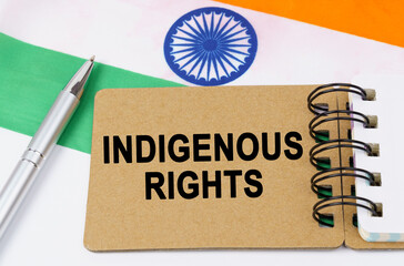 Against the background of the flag of India lies a notebook with the inscription - INDIGENOUS RIGHTS