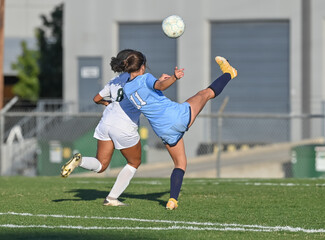 Young athletic girl making an amazing play during a soccer match © Joe