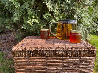 A teapot with hot herbal tea stands on a wicker basket. In cold autumn weather, you always want to...