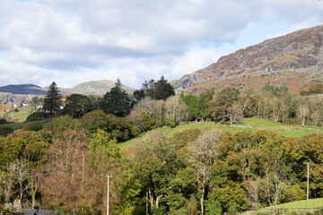 landscape view of hills, mountains and trees looking towards Blaenau Ffestiniog, North Wales, with blue sky and clouds