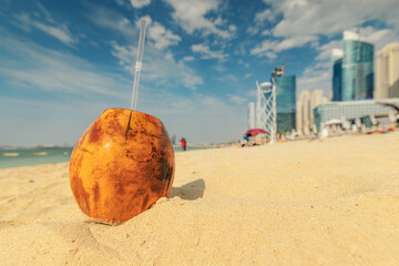Sweet coconut drink on the sandy jbr beach in Dubai. The concept of rest and vacation in a tropical resort