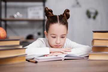 school, homework and education concept - bored or tired cute school girl with heap of books doing homework at home