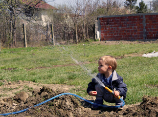 little boy watering the garden