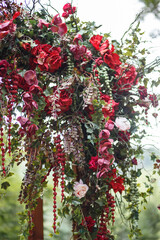 Floral arrangement of red flowers and leaves for wedding decoration. Floristry and decor concept
