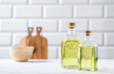 Natural vegetable oil in a clear bottle on the kitchen table. Dietary healthy food