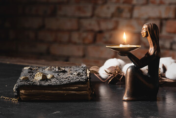 Ancient magic book and burning candle on the table close up. The witchcraft concept.