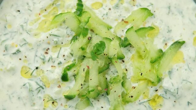 Tzatzik yogurt cucumber white sauce in bowl. rotating video
