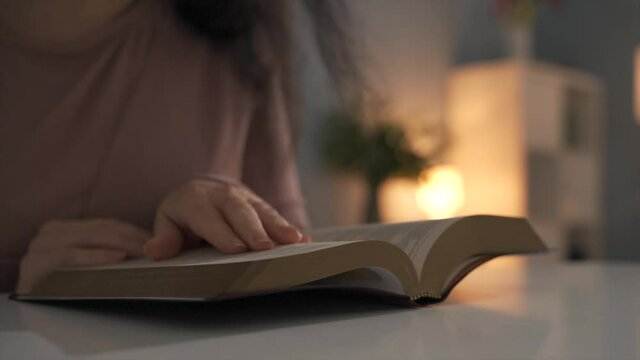 Shot fo woman's hands opening and reading book. Holy Bible study concept