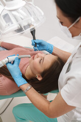 Vertical top view shot of a young woman getting professional dental treatment at the clinic