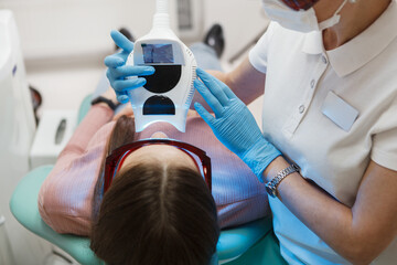 Close up of a female patient getting teeth whitening at dental clinic