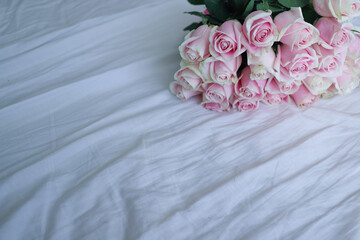 a bouquet of pink roses on a white sheet
