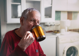 Old man drinking tea at home