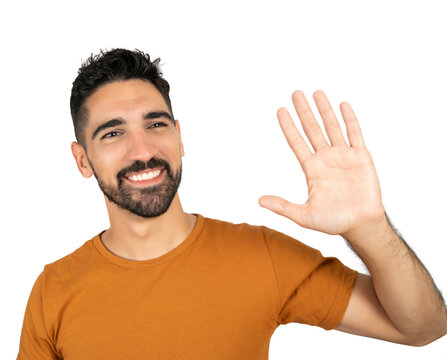 Young man waives hand in hello gesture.