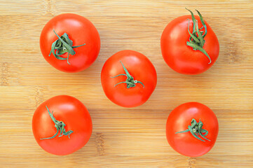 Red tomatoes on a wooden kitchen chopping board