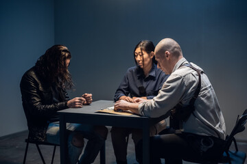 The murder suspect is in the interrogation room with a grim investigator and lawyer.